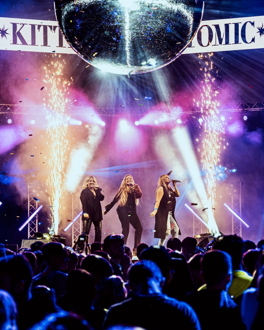 Atomic Kitten singing under a mirror ball as spark fountains fire either side of the stage